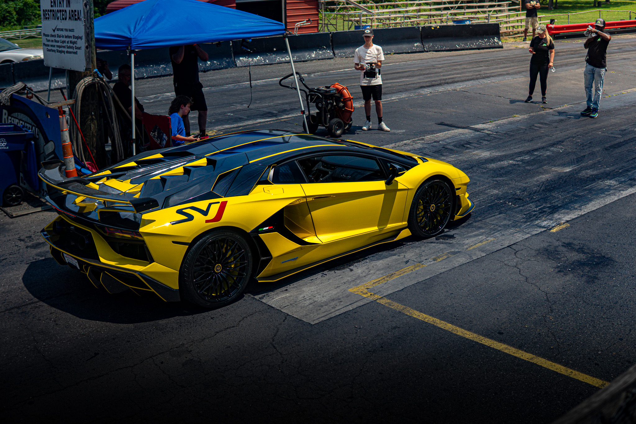 Yellow Lamborghini Aventador SVJ at a drag strip