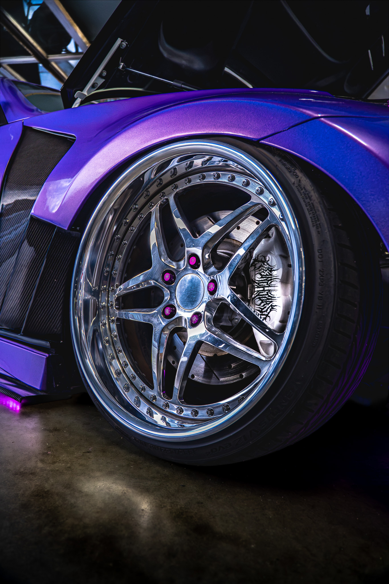 Close-up of a purple widebody sports car's wheel and fender