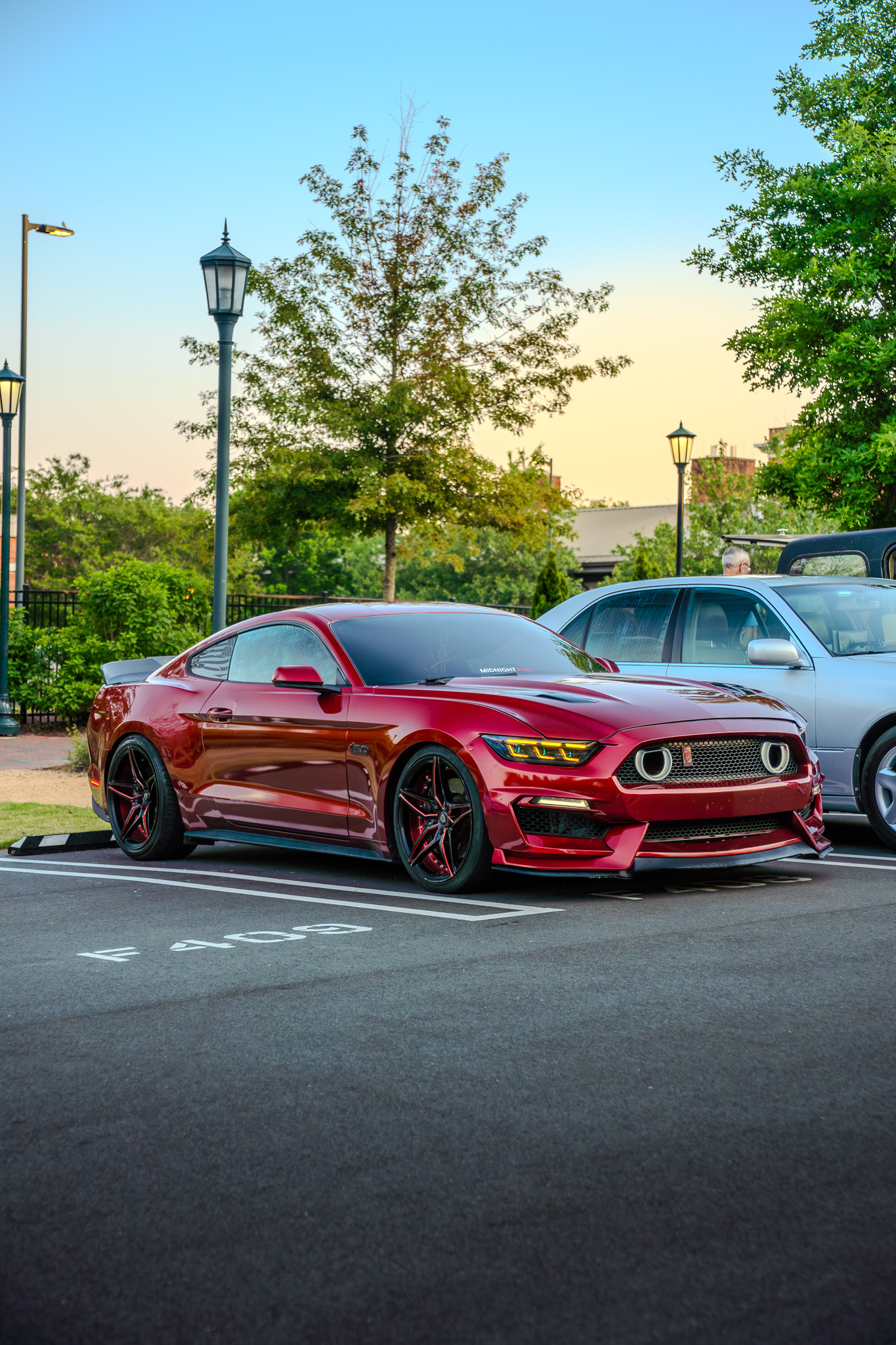 Red Ford Mustang GT at golden hour in a park