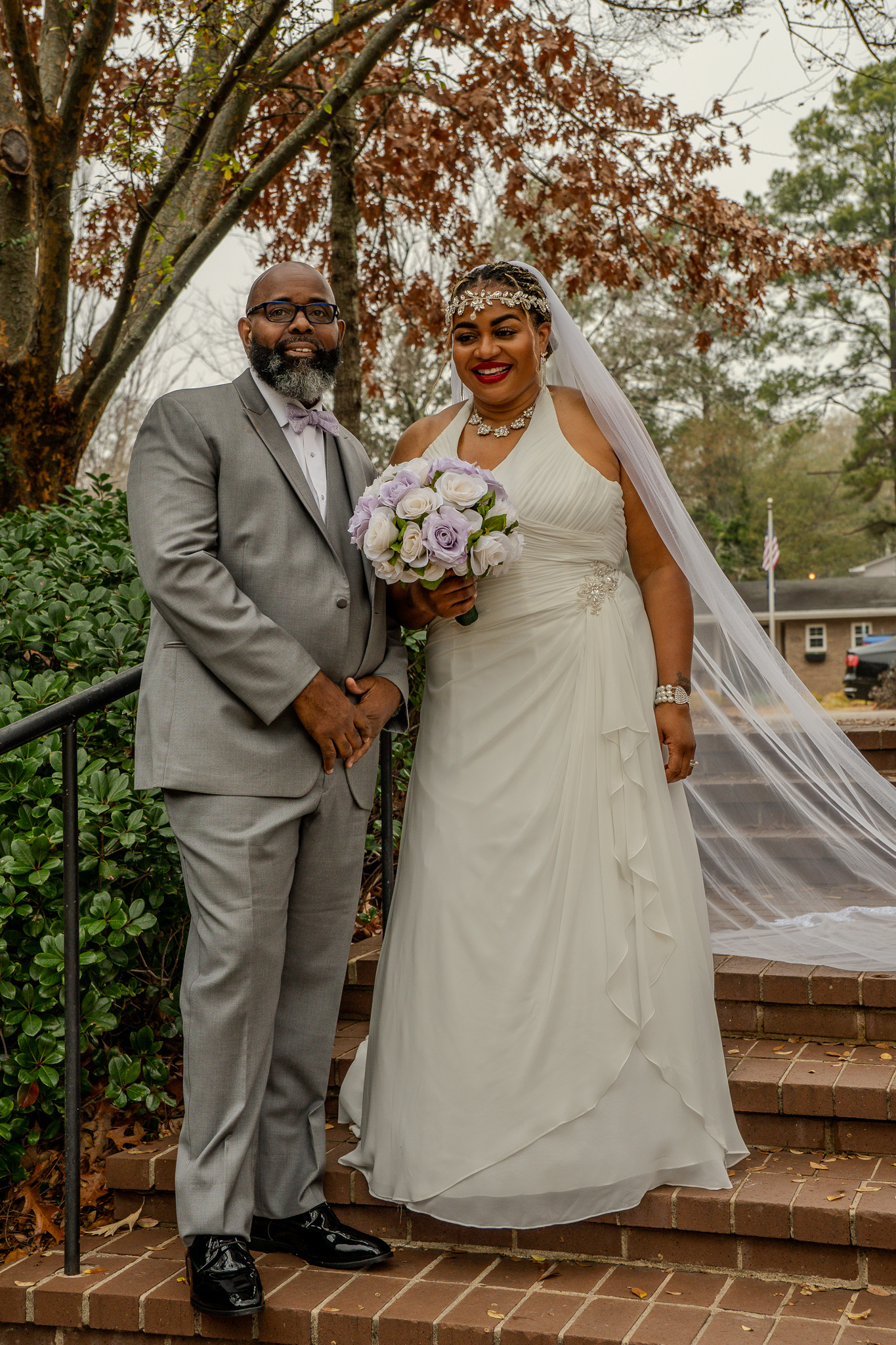Bride and groom portrait on brick steps with flowing veil
