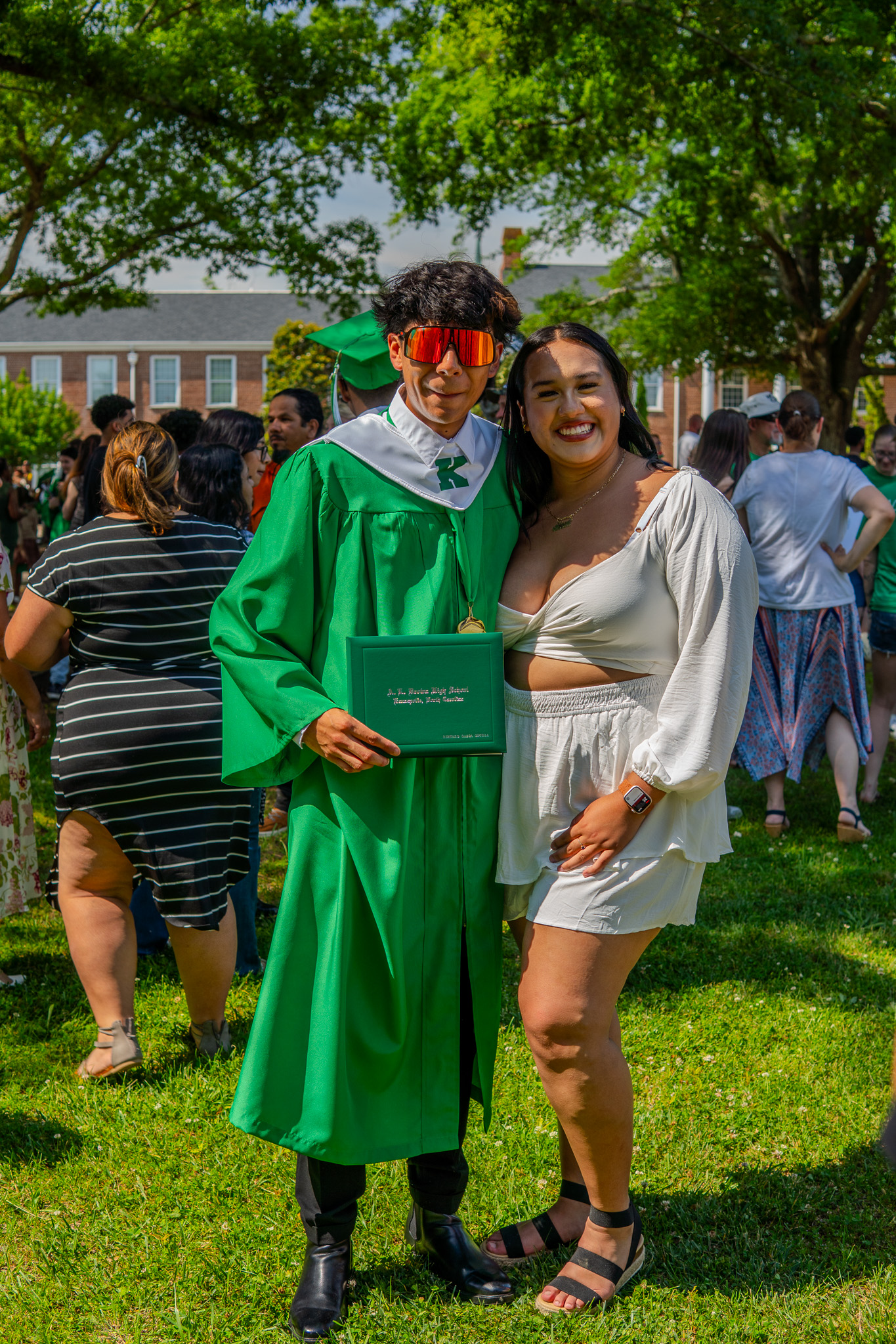 Graduate portrait with diploma on campus