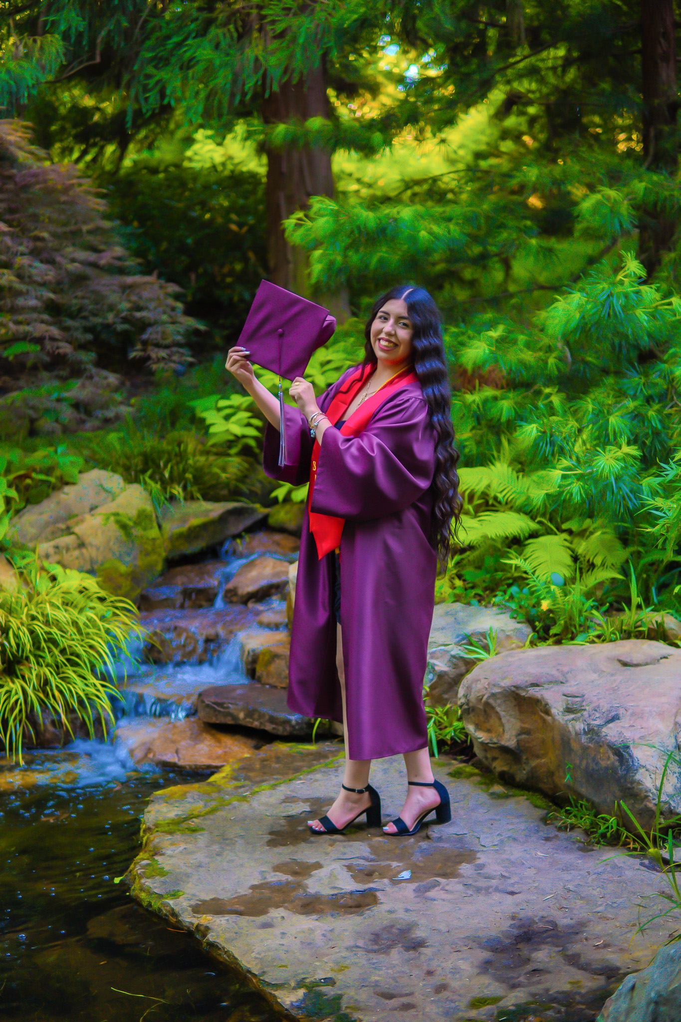 Graduate holding cap in a garden setting